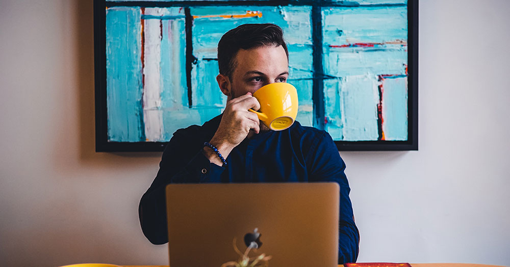 Person drinking at laptop